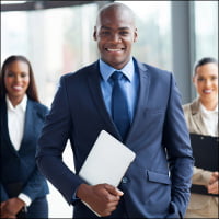 handsome african businessman with group of businesspeople on background