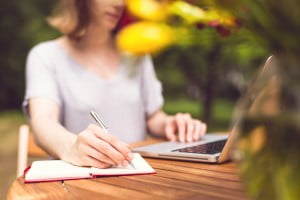 Freelancer working in the garden. Writing, surfing in the internet. Young girl. Relax and joy.